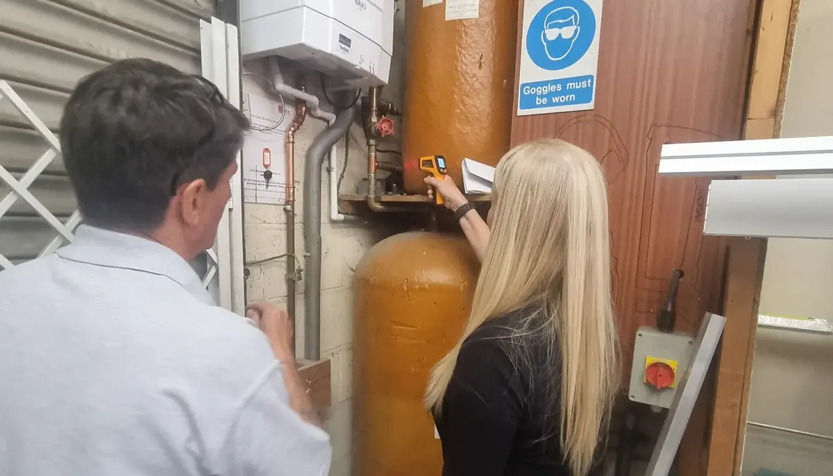 Learner carrying out a temperature check on a hot water system during Legionella training